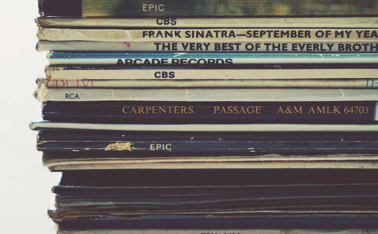 Close-up view of a stack of vintage vinyl records showcasing album spines.